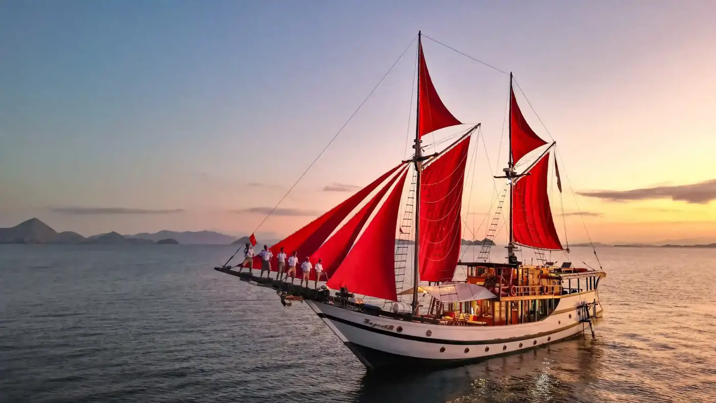Phinisi with red sails at sunset