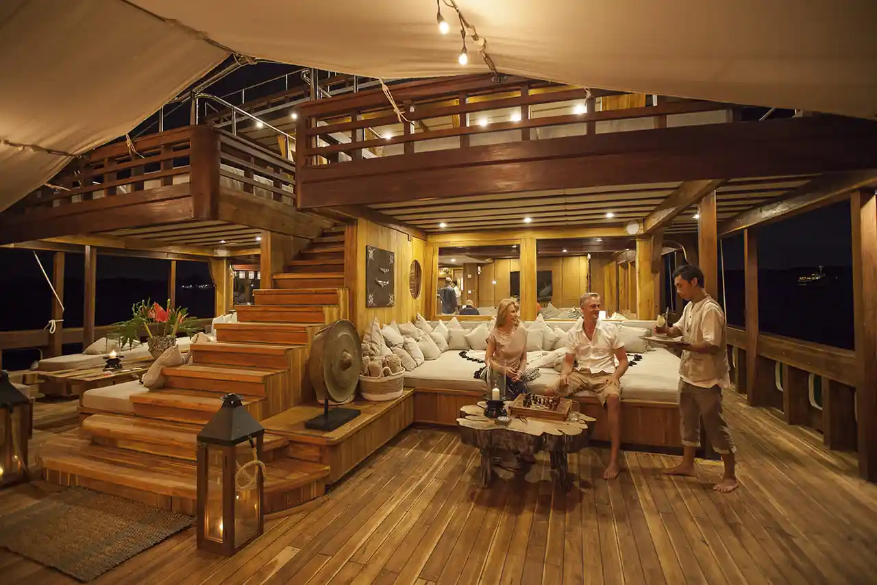 Indoor lounge on a phinisi with crew