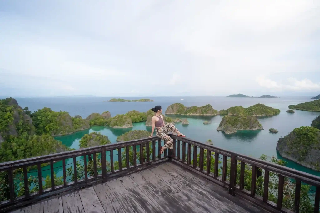 Traveller at a hilltop viewpoint above karst islands and lagoons